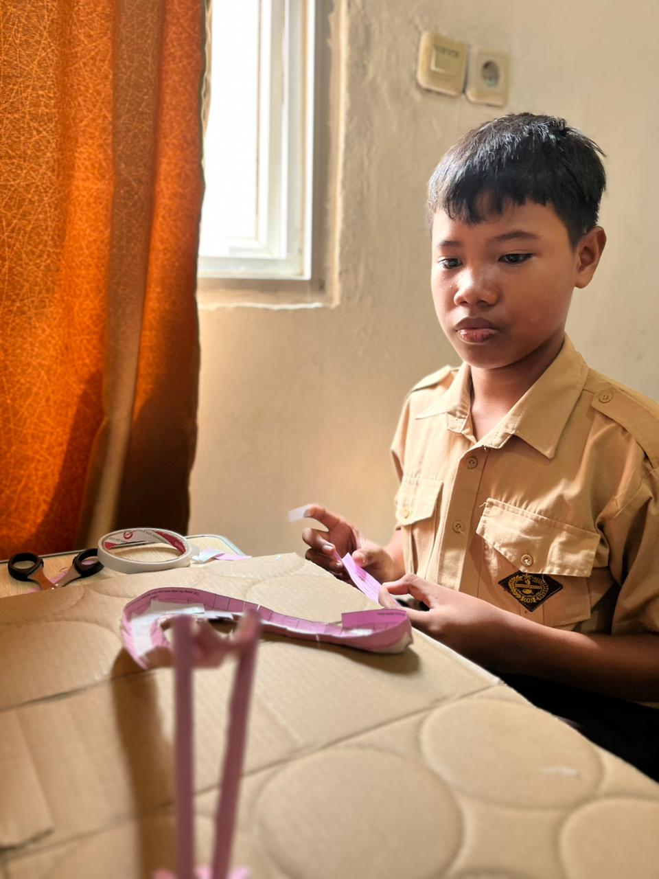 Siswa fokus membuat fondasi paper roller coaster